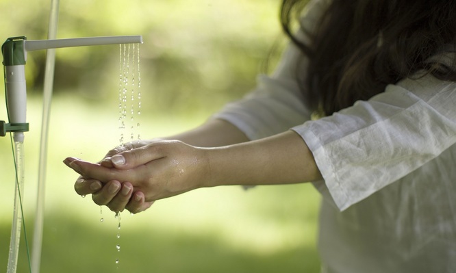 woman washing hands at portable sink
