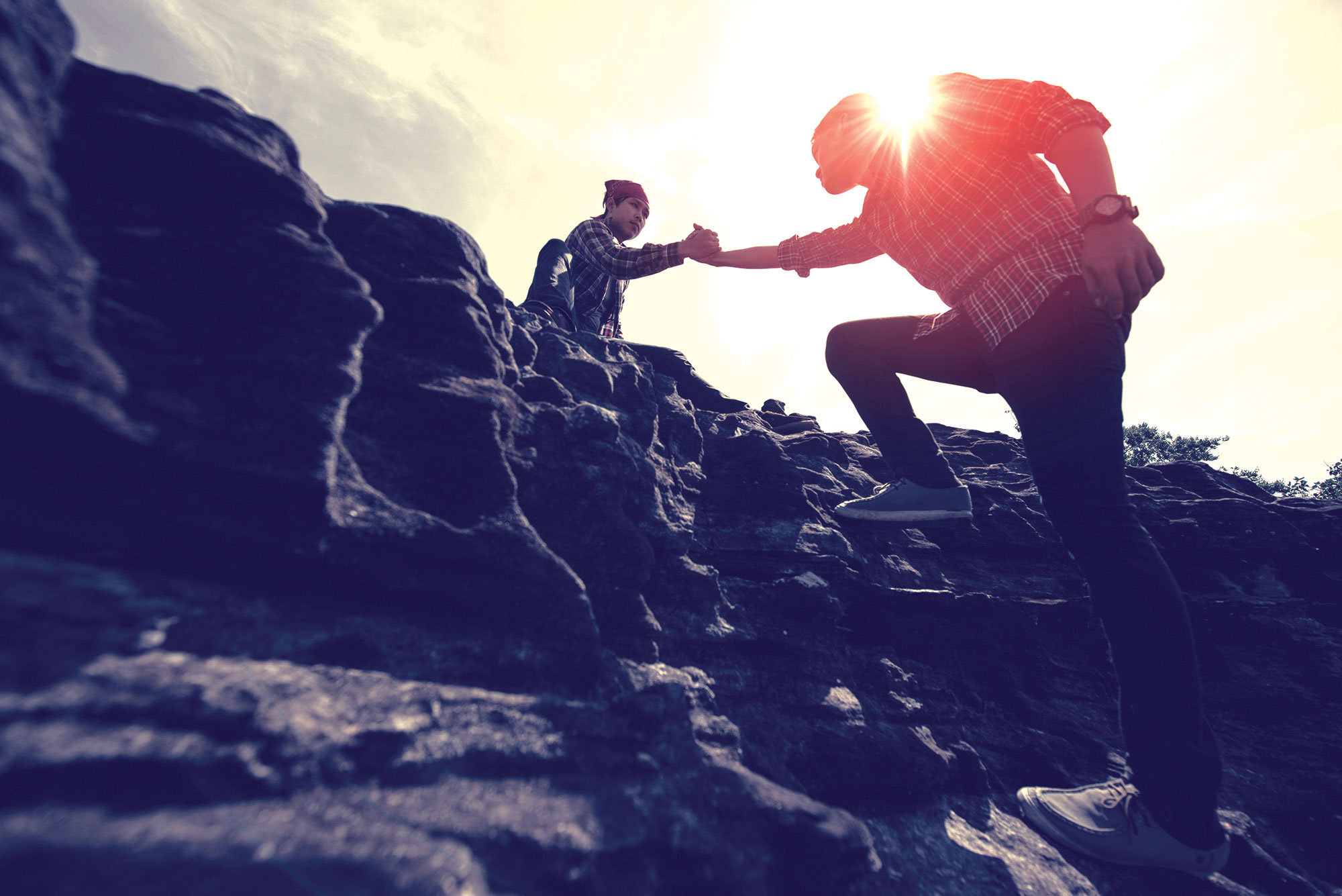 Mężczyzna podaje drugiemu mężczyźnie pomocną dłoń