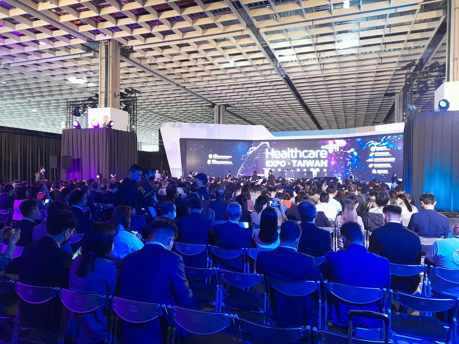 widok na grupę ludzi zgromadzonych na sali podczas konferencji