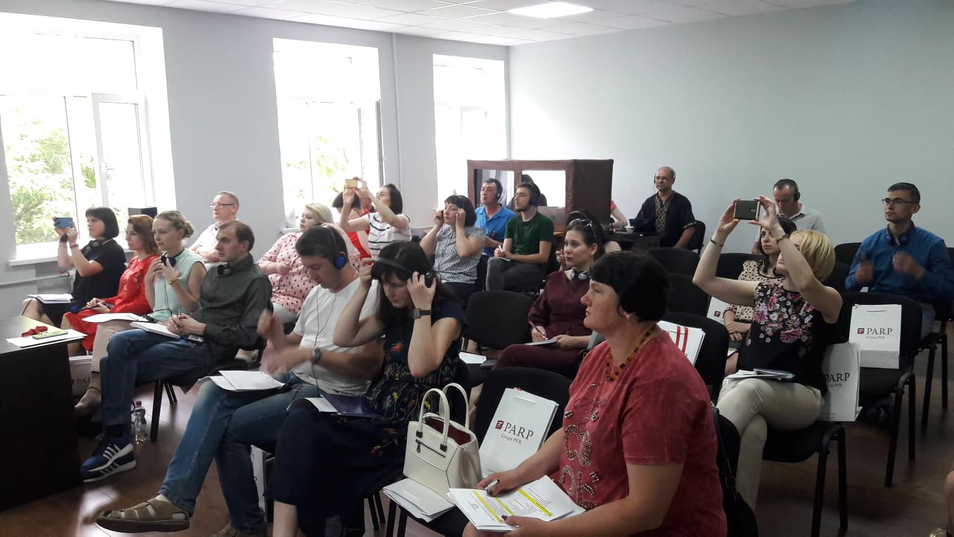 Przedstawiciele ukraińskiej administracji siedzą na sali i robią notatki podczas szkolenia PARP