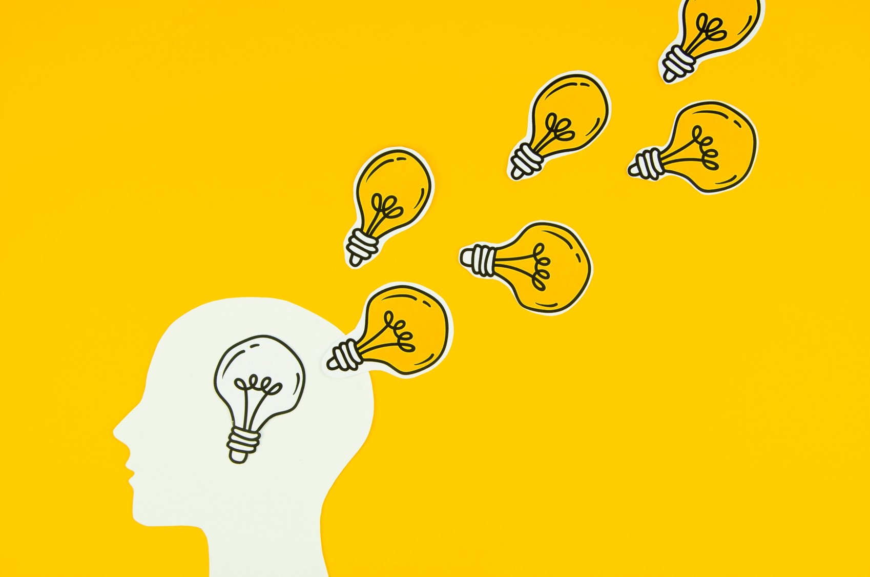 Na grafice widoczny jest kształt głowy człowieka i żarówki - jako symbol pojawiających się w...