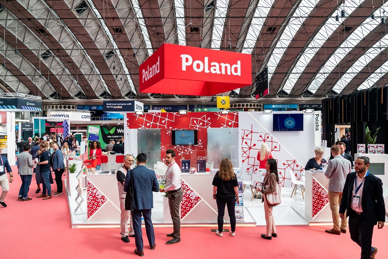 Ludzie w różnym wieku siedzą w hali targowej przy stolikach