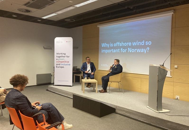 Ludzie siedzą na sali i patrzą się w obraz z projektora