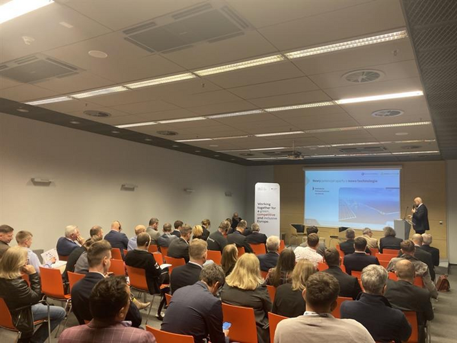 Ludzie siedzą na sali i patrzą się w obraz z projektora