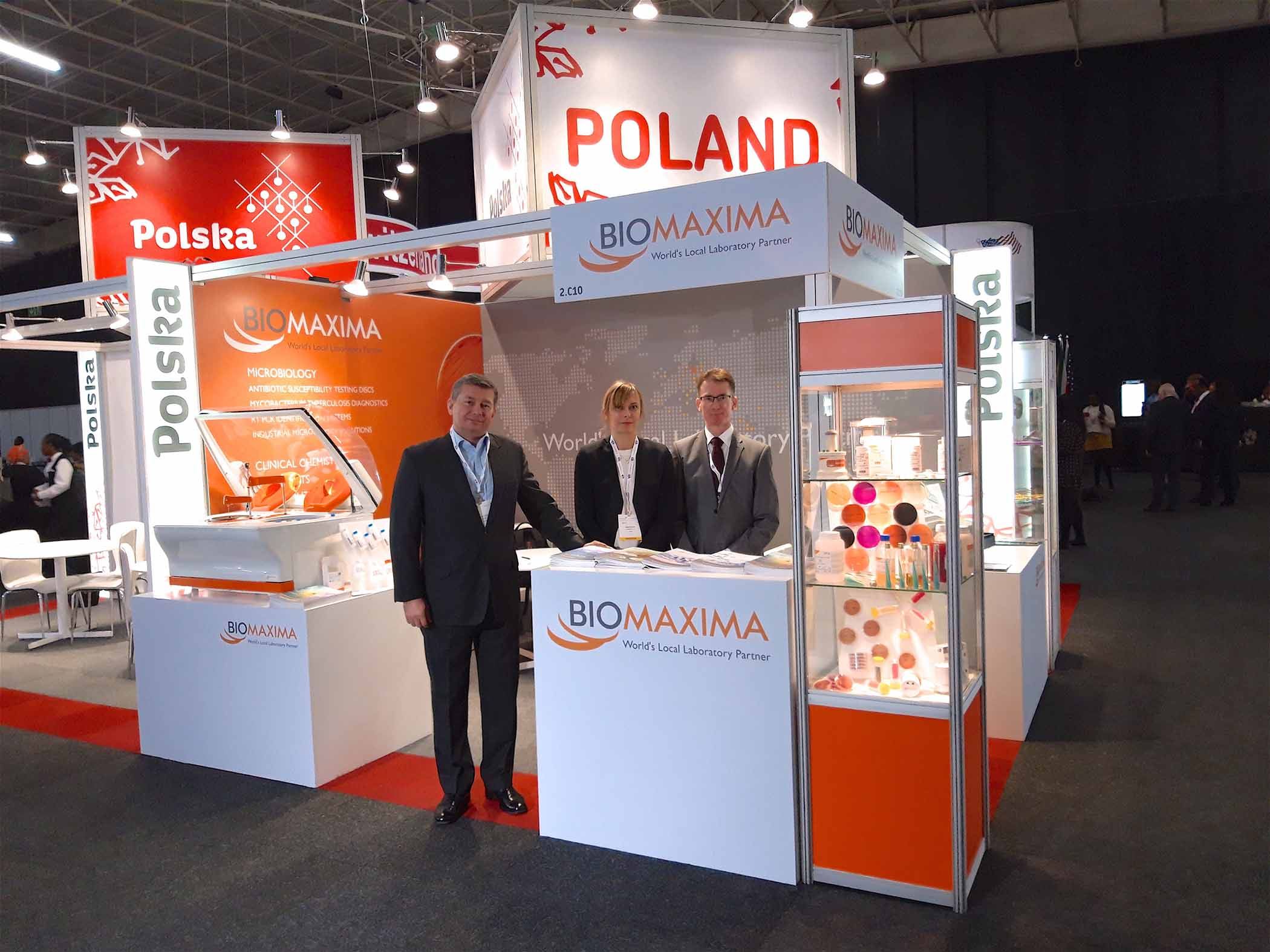Zdjęcia sotiska targowego z uczestnikami, oszyldowane nazwą BioMaxima