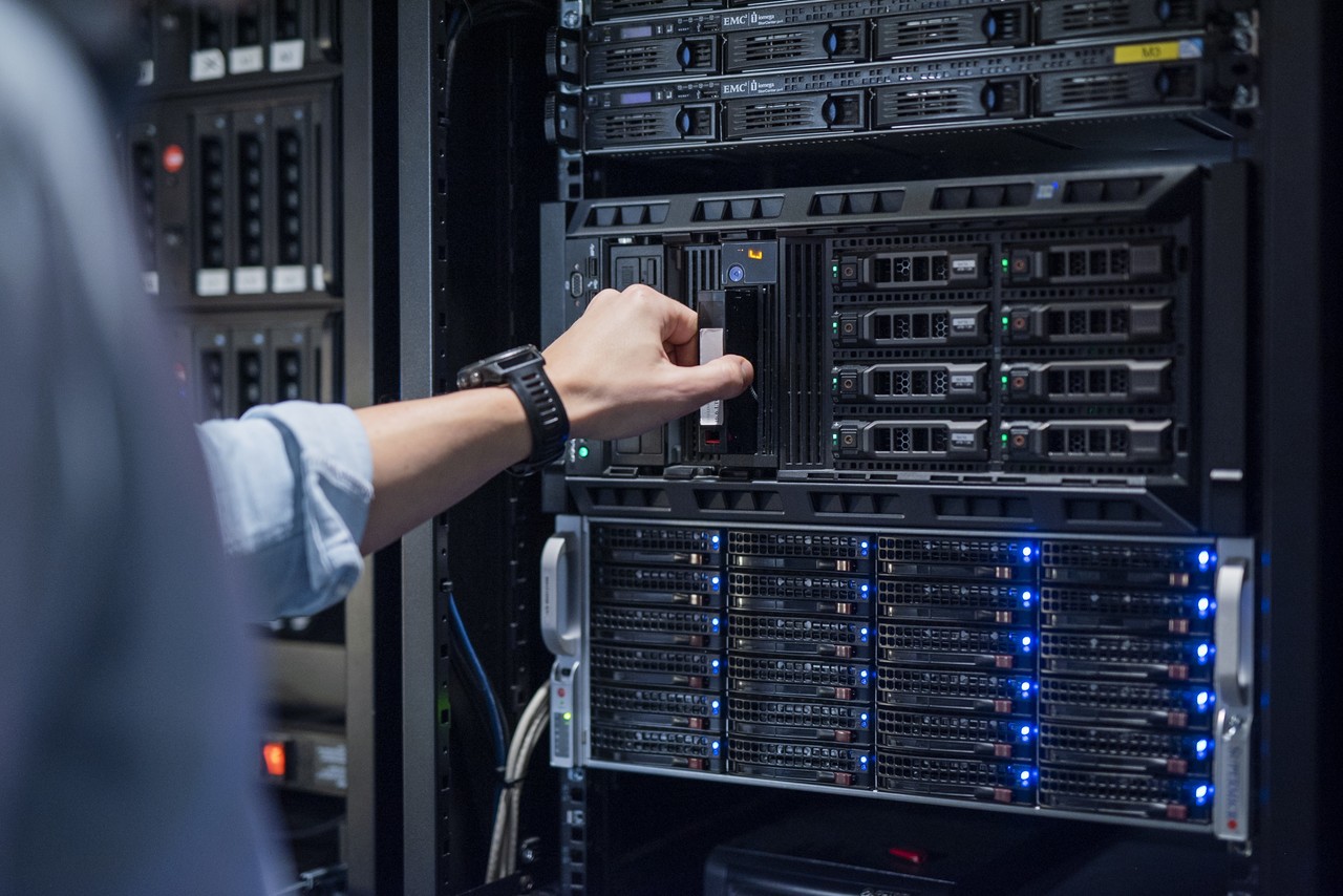 Ręka przyciska guzik na ścianie z urządzeniem