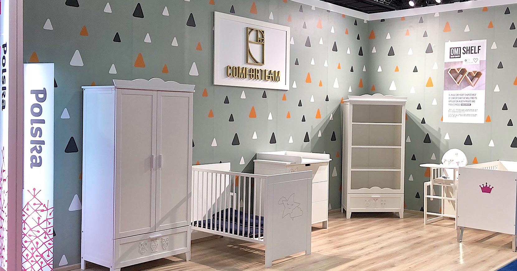 Widok stoiska targowego z meblami do pokoju dziecięcego: szafa, łóżeczko, przewijak