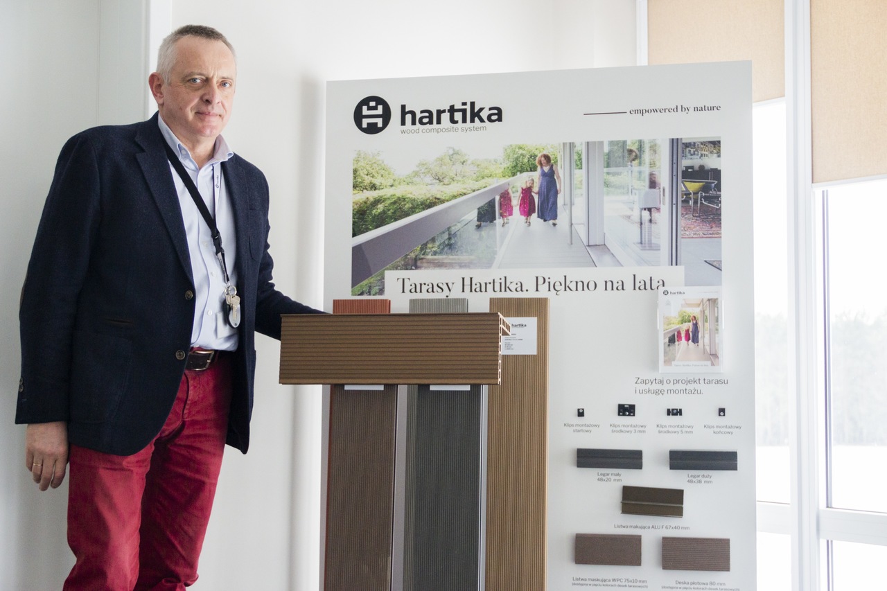 Mężczyzna na tle ściany z drewnianymi częściami