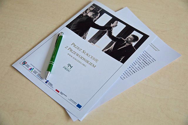 Widok biurka, stołu, na którym połozona jest kartka z napisem &quot;Przez sukcesję z przewodnikiem&quot;