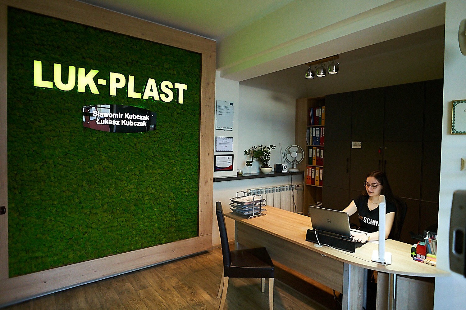 biuro firmy Luk Plat przy biurku siedzi kobieta w okularach 